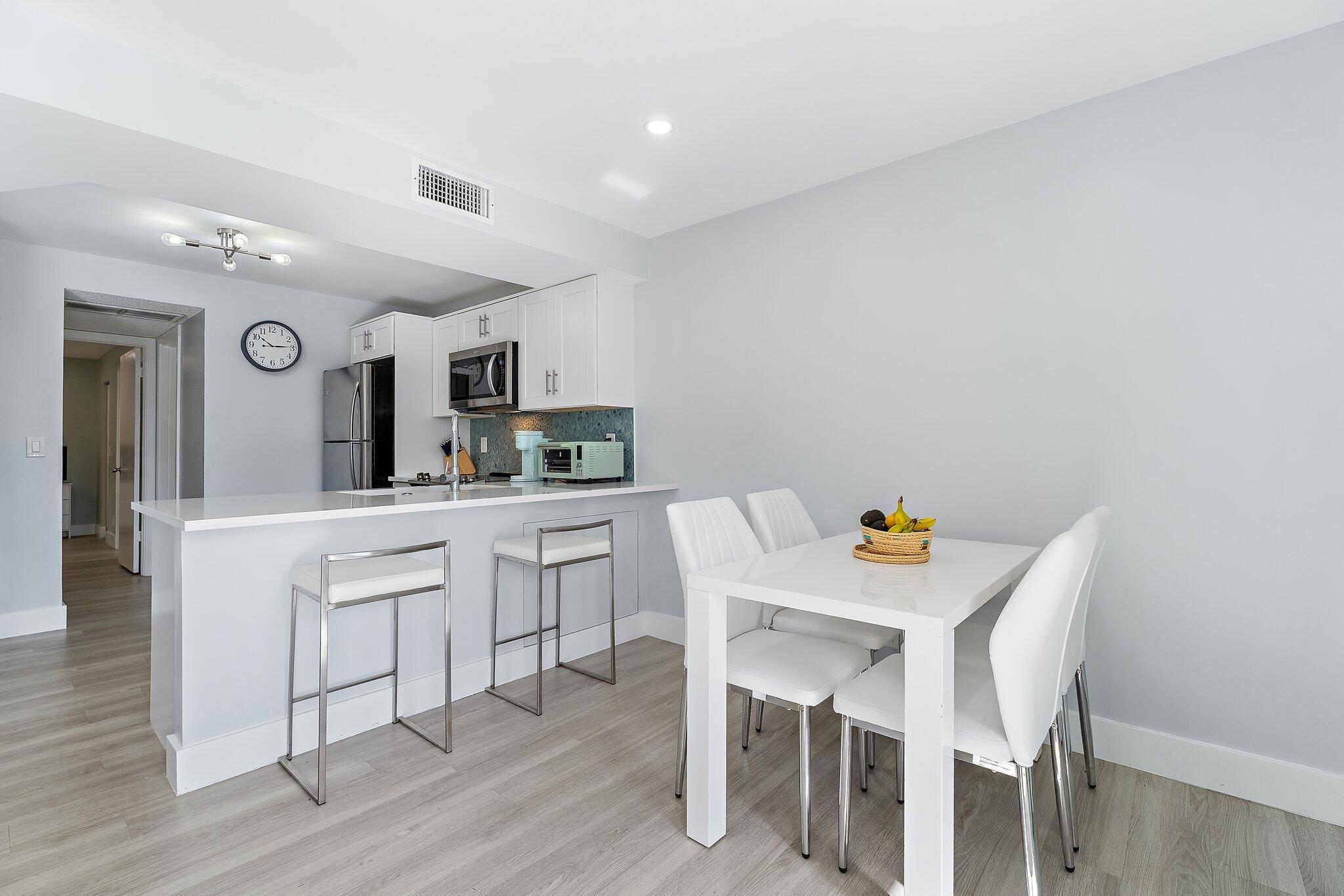 1605 Highway 1, Unit V2204 Jupiter, FL 33477 - Photo 10 of 36 a kitchen with stainless steel appliances cabinets and wooden floor