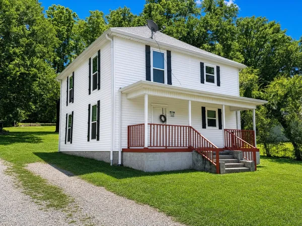 a view of a house with a yard deck and a small yard