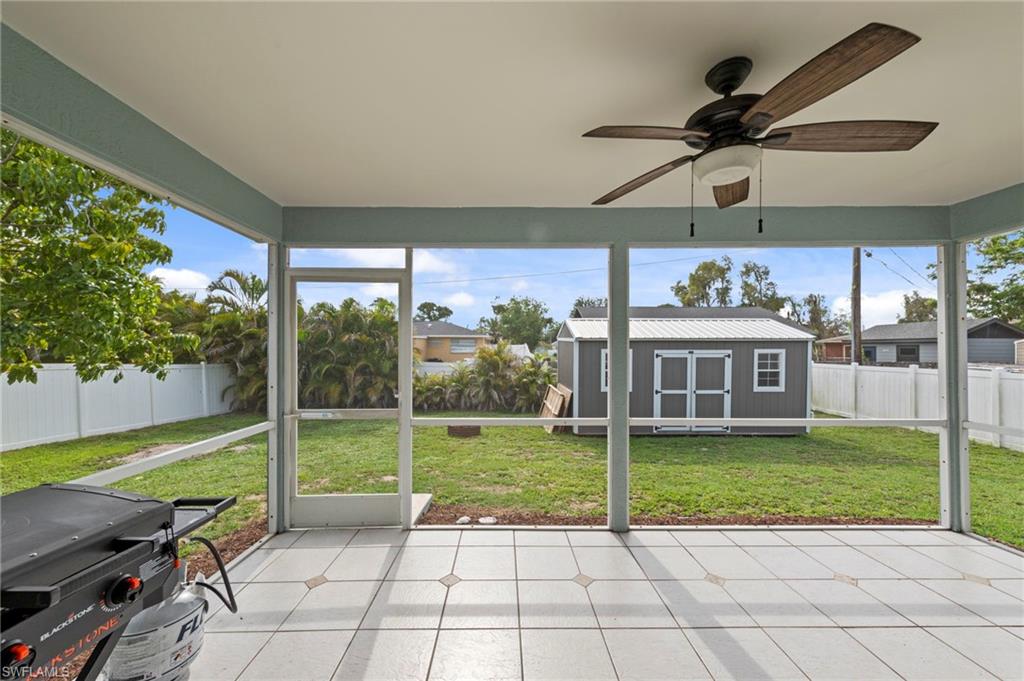 18435 Heather Road Fort Myers, FL 33967 - Photo 22 of 34 Screened patio featuring a ceiling fan with light fixture, tiled flooring, and a shed with a metal roof