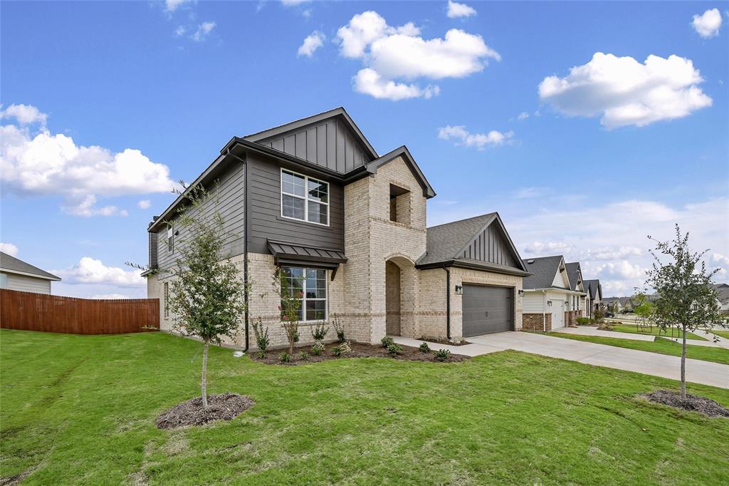 1205 Colca Drive Springtown, TX 76082 - Photo 4 of 37 Two-story exterior featuring a brick and siding facade, covered front entry, attached garage, and a manicured lawn