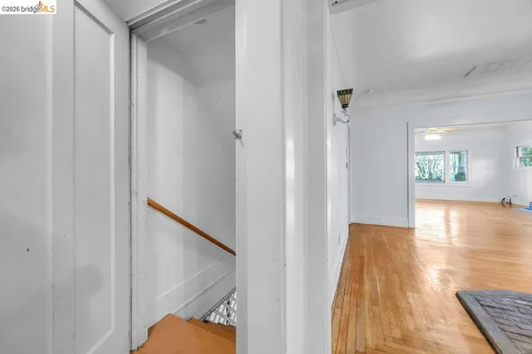 a view of a hallway with wooden floor and staircase