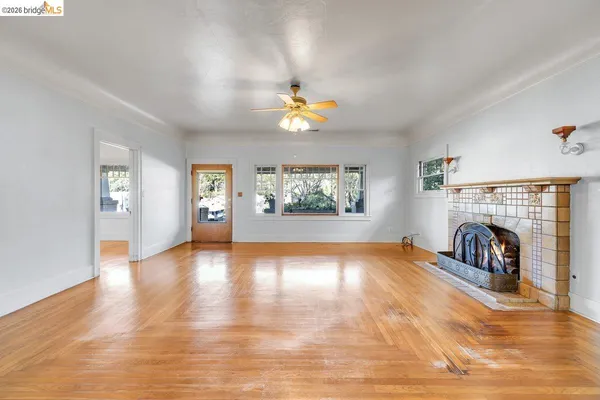 a view of an empty room window and wooden floor