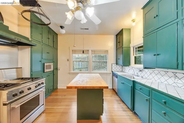 a large kitchen with kitchen island a large counter space a sink appliances and cabinets