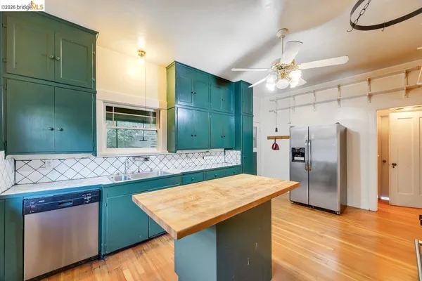 a kitchen with kitchen island a sink stainless steel appliances and refrigerator