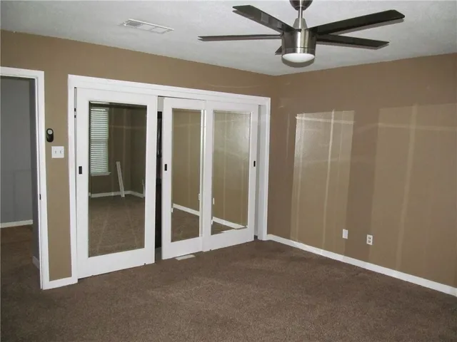 an empty room with windows and fireplace