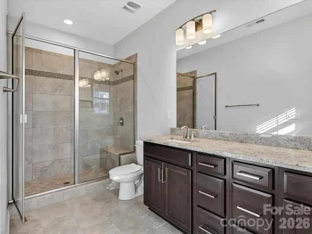 a bathroom with a granite countertop sink toilet and shower