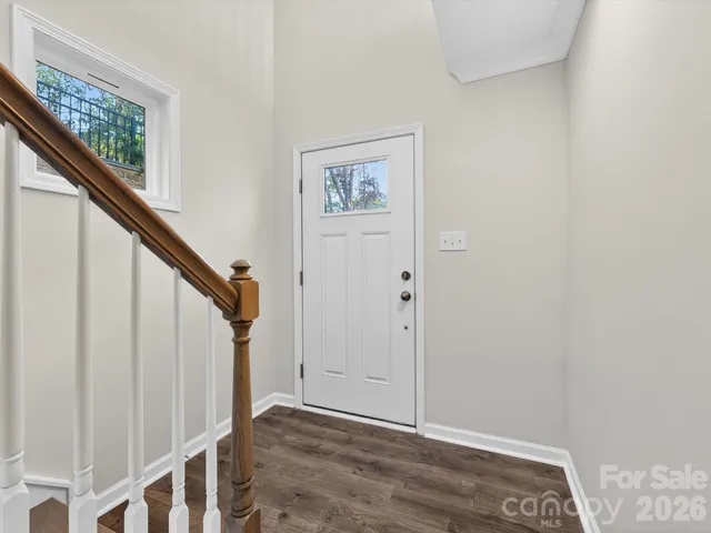 a view of staircase with wooden floor and white walls