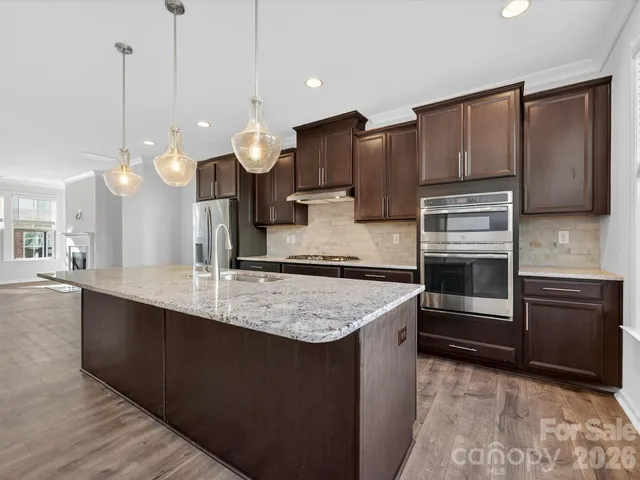 a kitchen with kitchen island a counter space a sink and stainless steel appliances