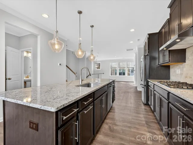 a kitchen with kitchen island a sink stove and wooden floor