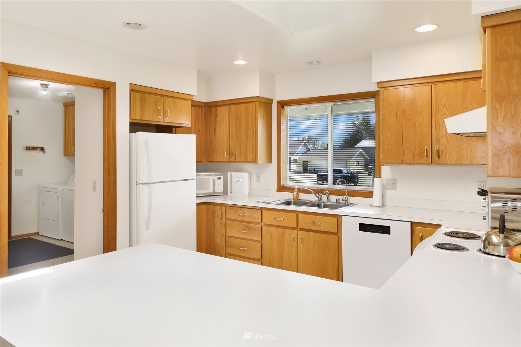 3938 Bowen Road Sumas, WA 98295 - Photo 8 of 34 a kitchen with a refrigerator a sink dishwasher with a dining table and chairs