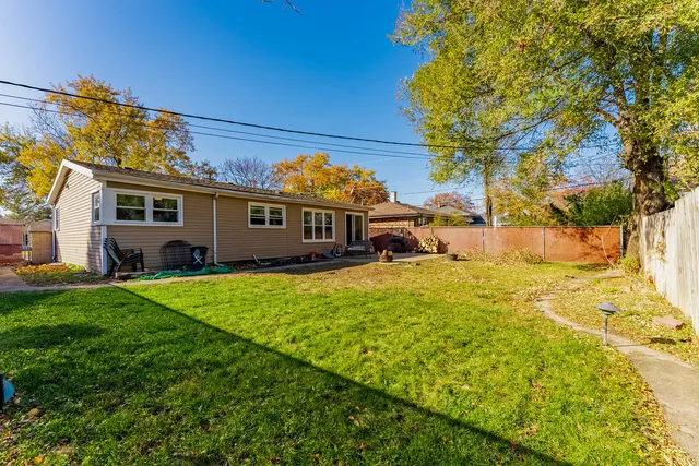 a view of a house with backyard and sitting area