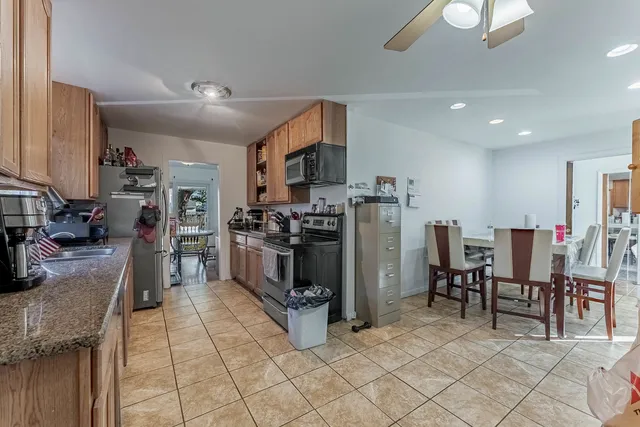 a kitchen with stainless steel appliances kitchen island granite countertop a refrigerator and microwave