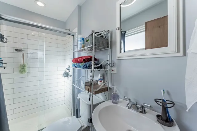 a bathroom with a sink a toilet and shower