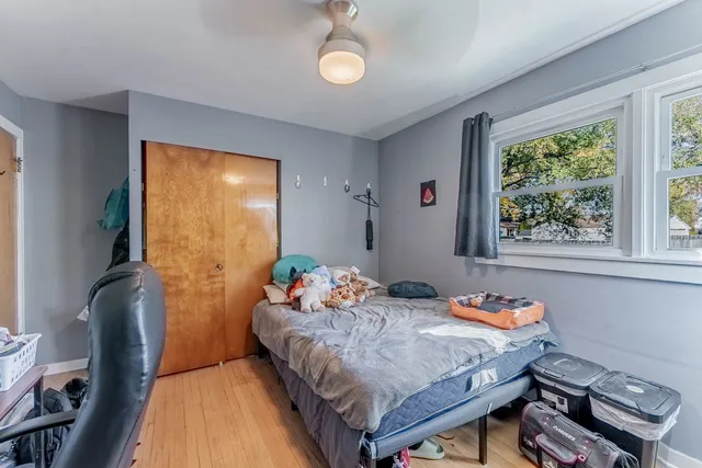 a bedroom with a bed and wooden floor