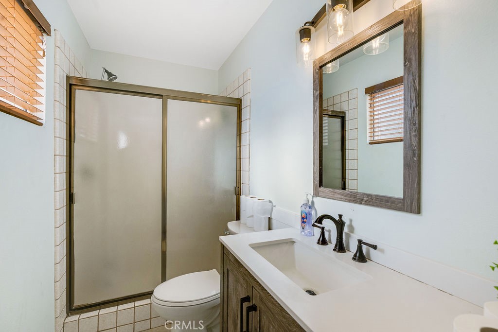 7365 Chase Hesperia, CA 92345 - Photo 13 of 21 a bathroom with a sink a mirror a toilet and shower