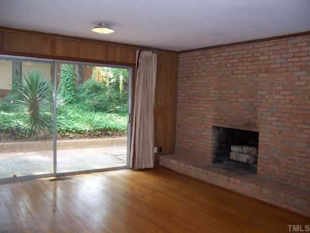 2501 10th Avenue Raleigh, NC 27612 - Photo 7 of 12 a view of empty room with wooden floor and a fireplace