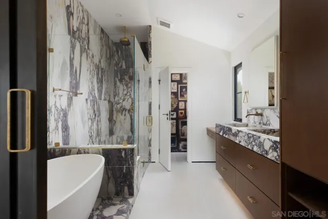 a bathroom with a tub sink and mirror