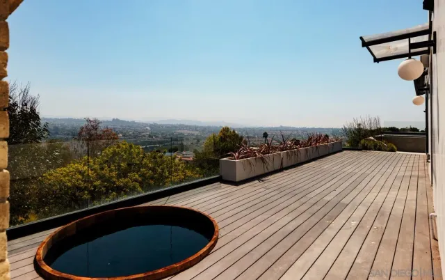 a terrace with outdoor seating and trees in the background