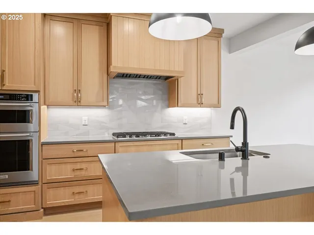 a kitchen with a sink a stove and cabinets