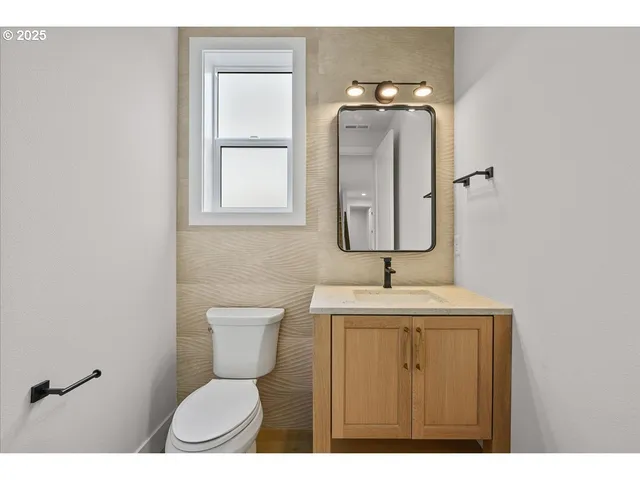 a bathroom with a toilet sink and mirror
