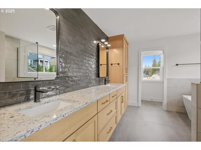a bathroom with a granite countertop sink mirror and a bathtub