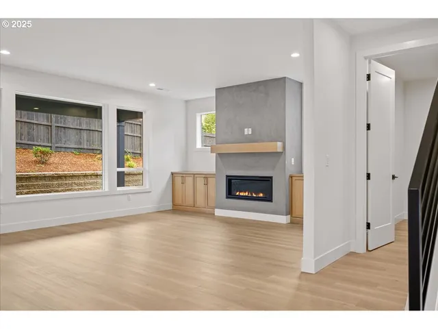 a view of empty room with wooden floor and fireplace
