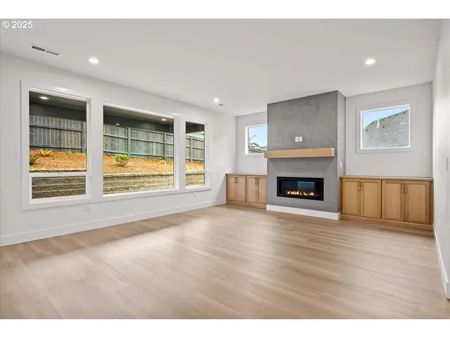 a view of empty room with wooden floor and fireplace