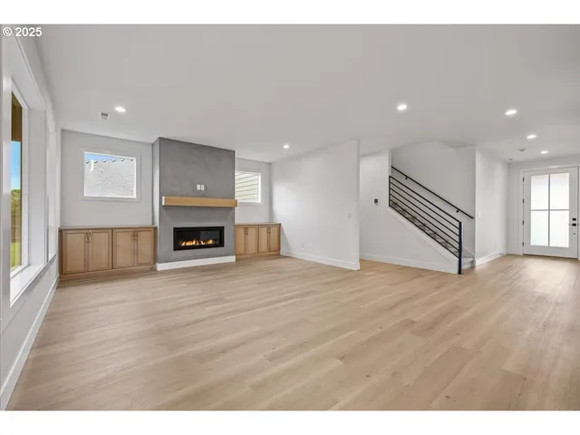 a view of a livingroom with wooden floor and a fireplace