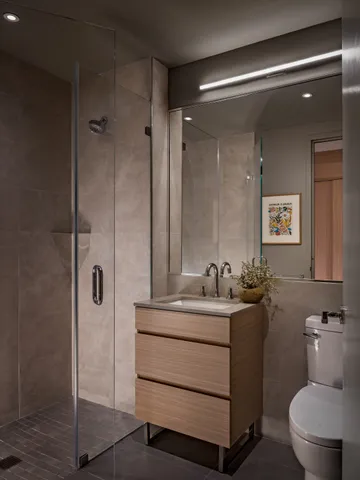 a bathroom with a sink toilet vanity and shower