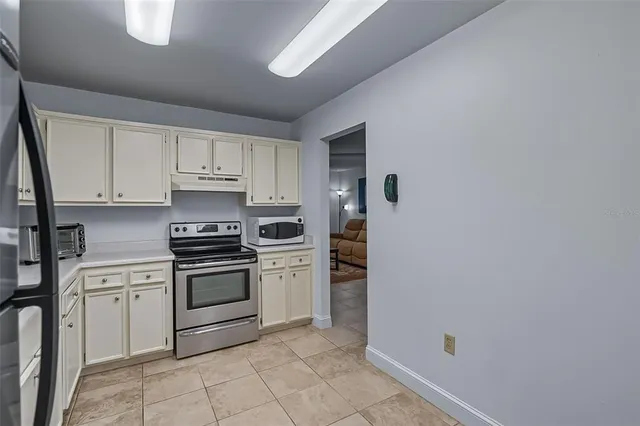 a kitchen with white cabinets and white appliances