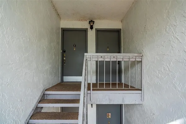 a view of staircase with white walls and a window