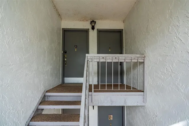 a view of staircase with white walls and a window
