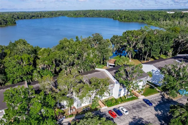 an aerial view of a house with a yard and lake view