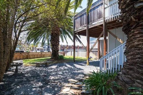 a view of a house with a yard and potted plants
