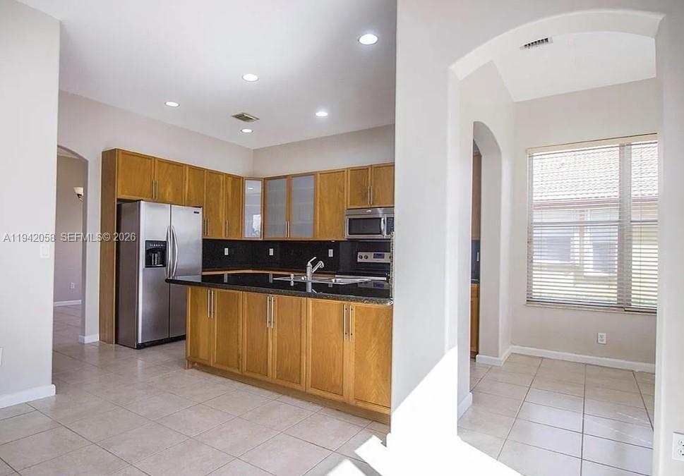 19416 Southwest 25th Court Miramar, FL 33029 - Photo 7 of 10 a kitchen with stainless steel appliances granite countertop a refrigerator and a stove top oven