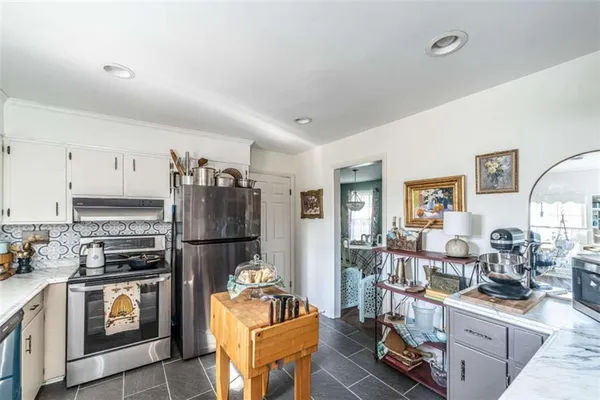 a kitchen with stainless steel appliances granite countertop a refrigerator stove and sink