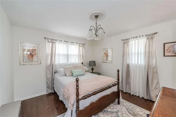 a bedroom with a bed a dresser and chair