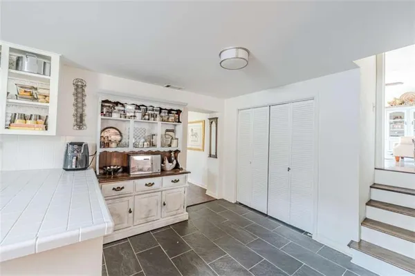 a kitchen with white cabinets and refrigerator