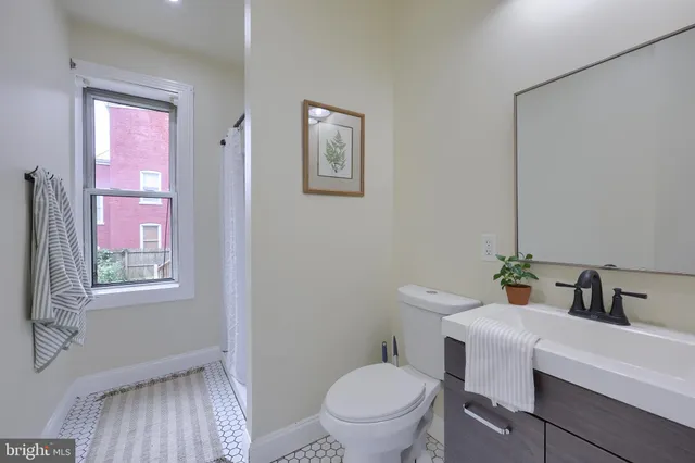 a bathroom with a sink a toilet and a mirror