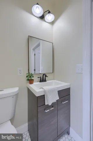 a bathroom with a sink a toilet a mirror and vanity