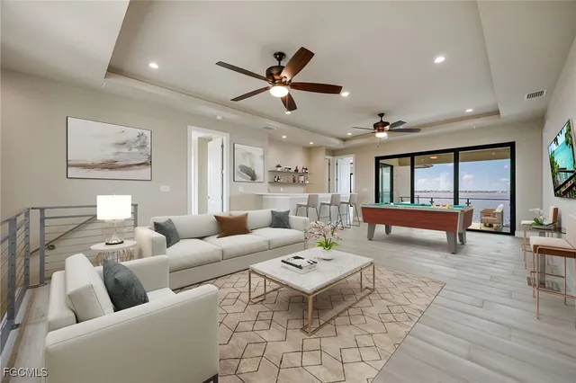a view of an empty room and kitchen with wooden floor