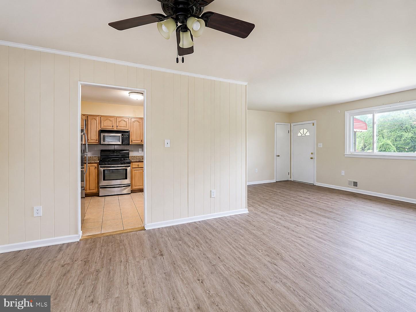11312 Old Fort Road Fort Washington, MD 20744 - Photo 6 of 13 an empty room with wooden floor and chandelier