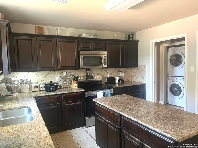 a kitchen with granite countertop white cabinets and window