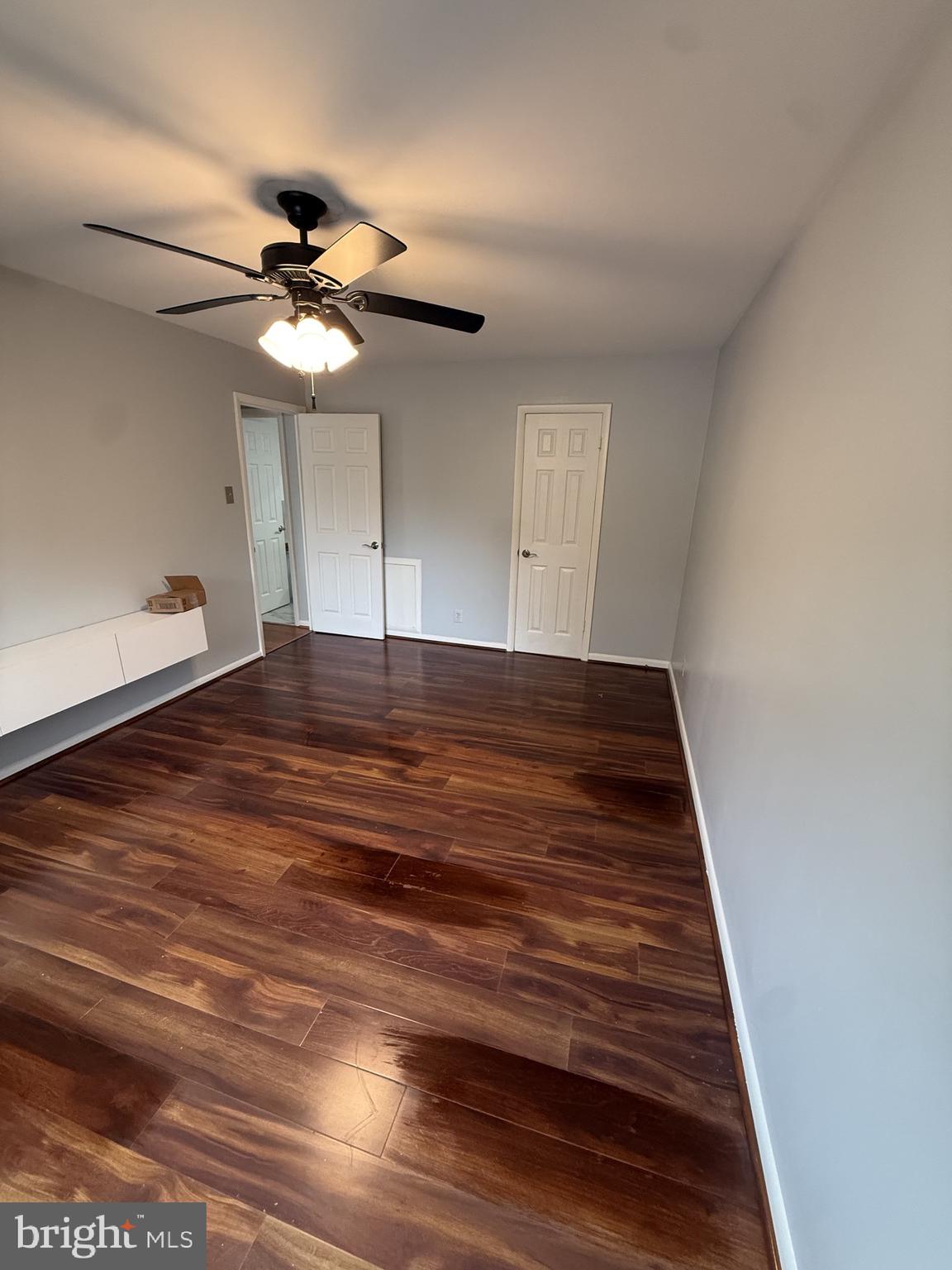 12650 Dara Drive, Unit 204 Woodbridge, VA 22192 - Photo 5 of 12 a view of an empty room with a chandelier fan and wooden floor