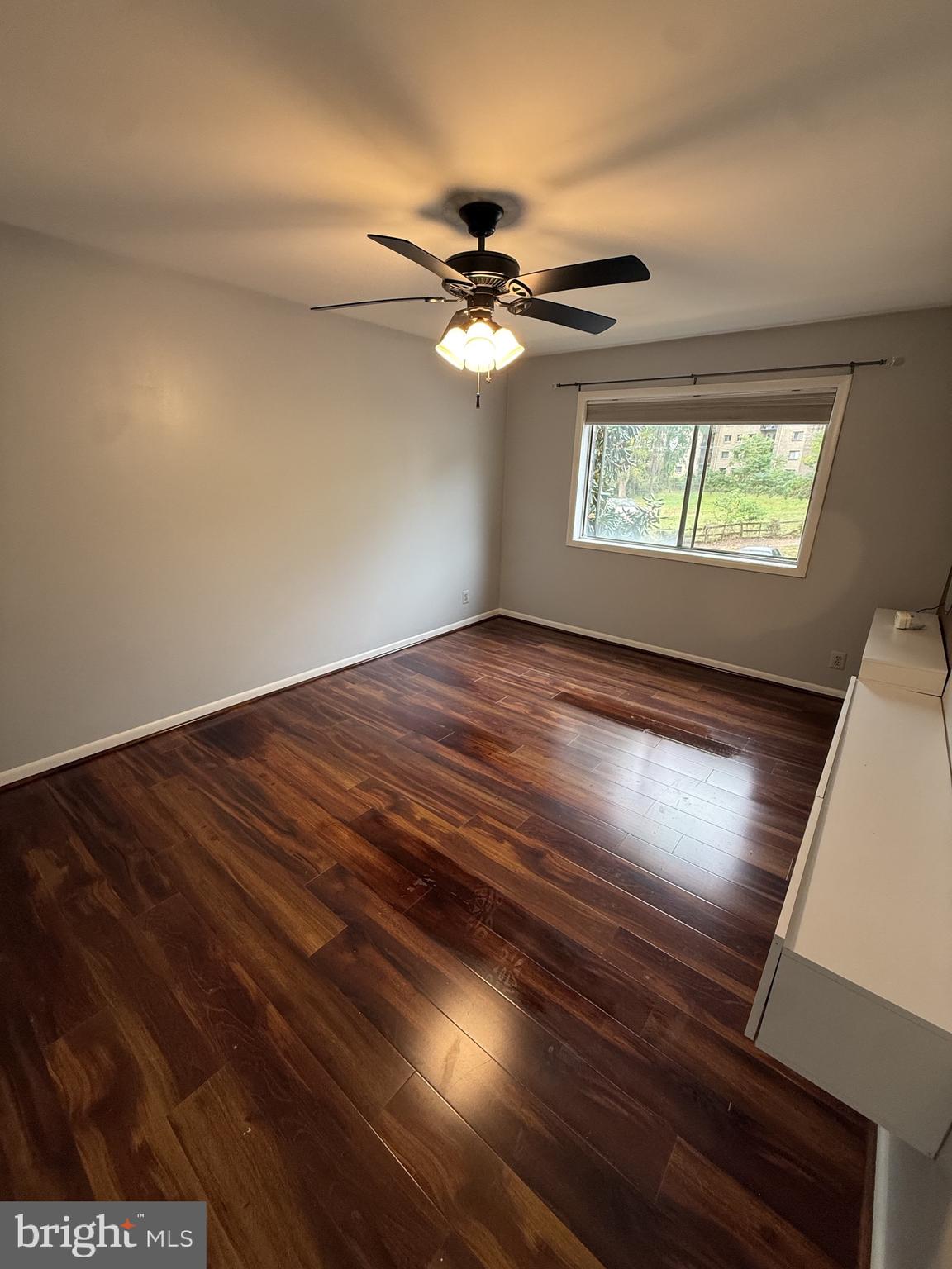 12650 Dara Drive, Unit 204 Woodbridge, VA 22192 - Photo 6 of 12 an empty room with wooden floor ceiling fan and windows