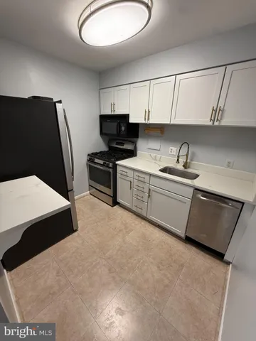 a kitchen with stainless steel appliances a stove a sink and a refrigerator