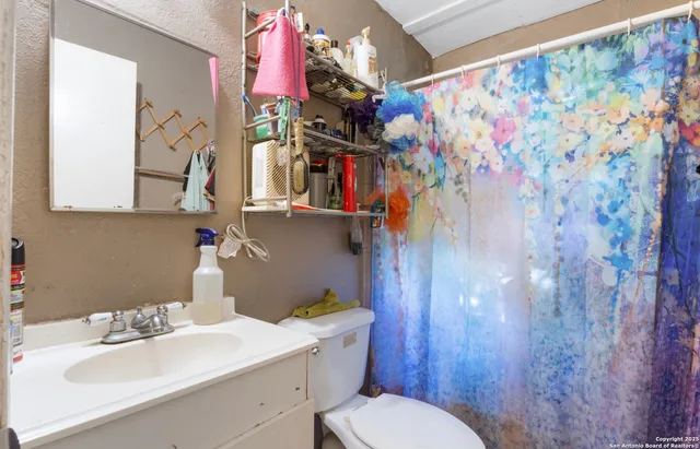 a bathroom with a sink mirror vanity and toilet
