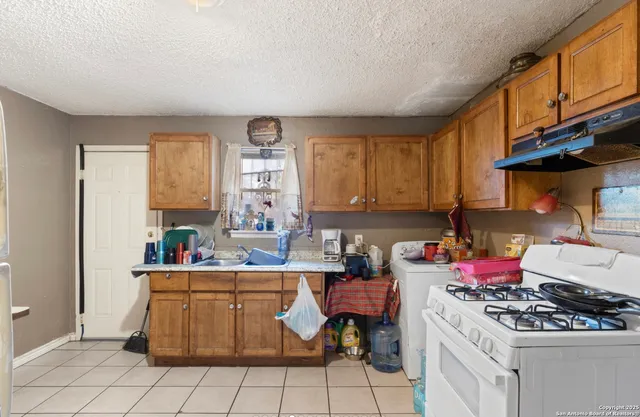 a kitchen with a stove a sink and a refrigerator