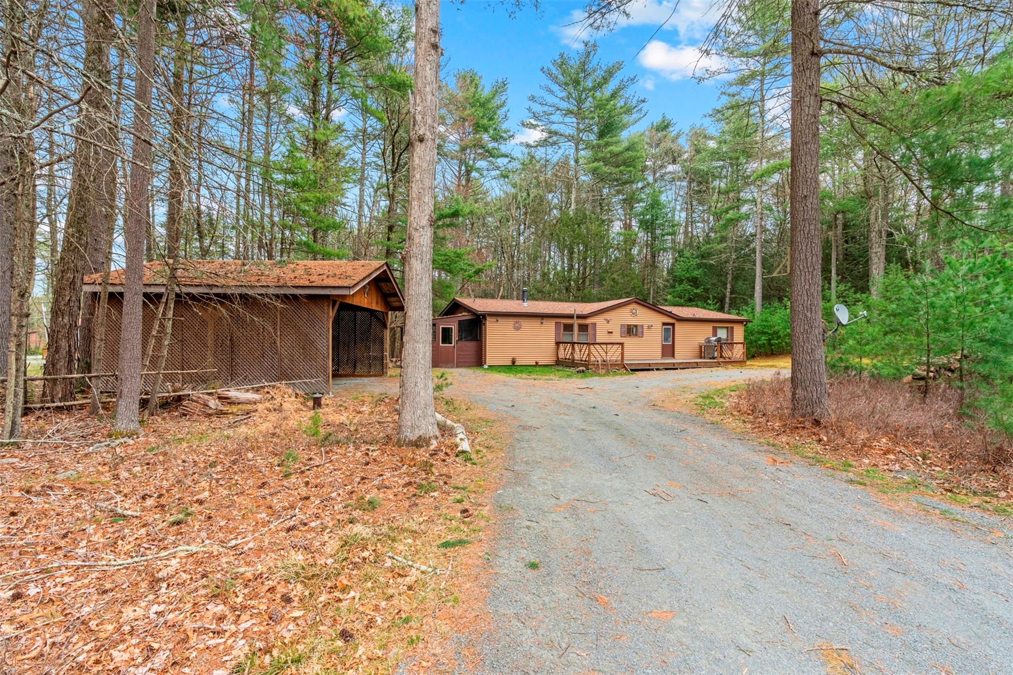 View of front of house featuring driveway and a deck