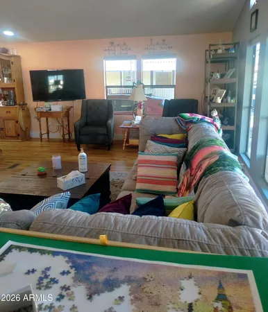 a living room with patio furniture and a flat screen tv